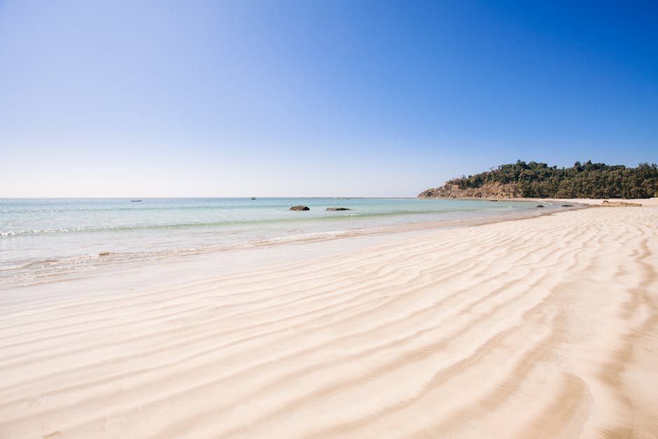 A serene view of a tranquil beach with clear ocean waters and soft sand in Myanmar.
